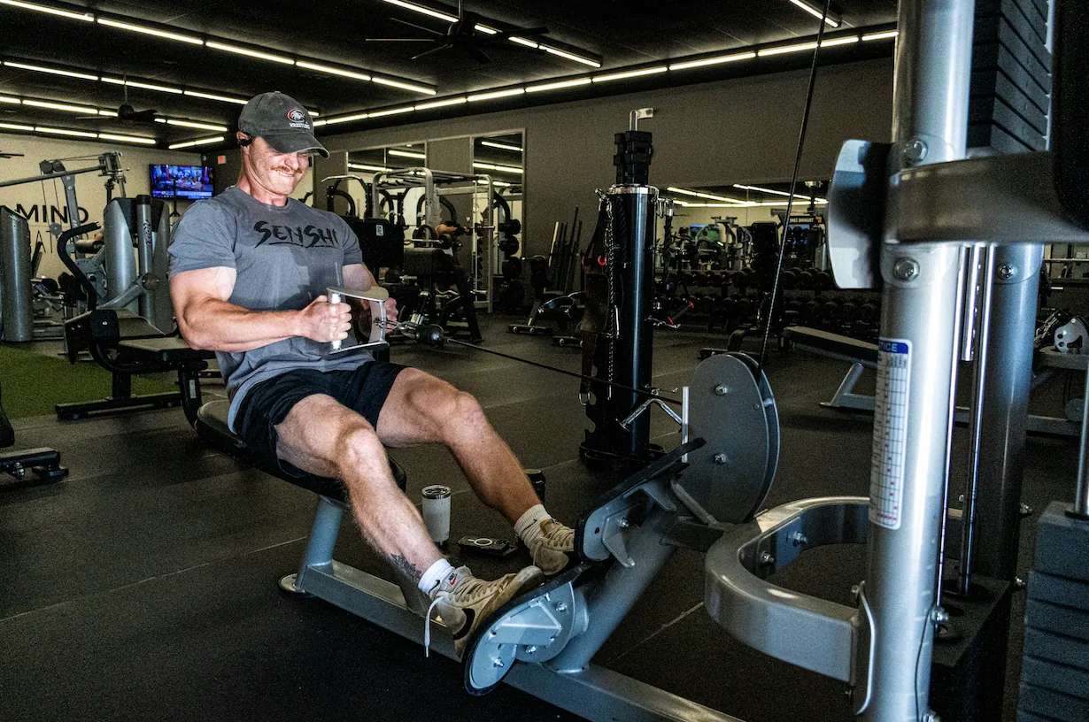 A member training on a cable row machine at The Training Room at The Center